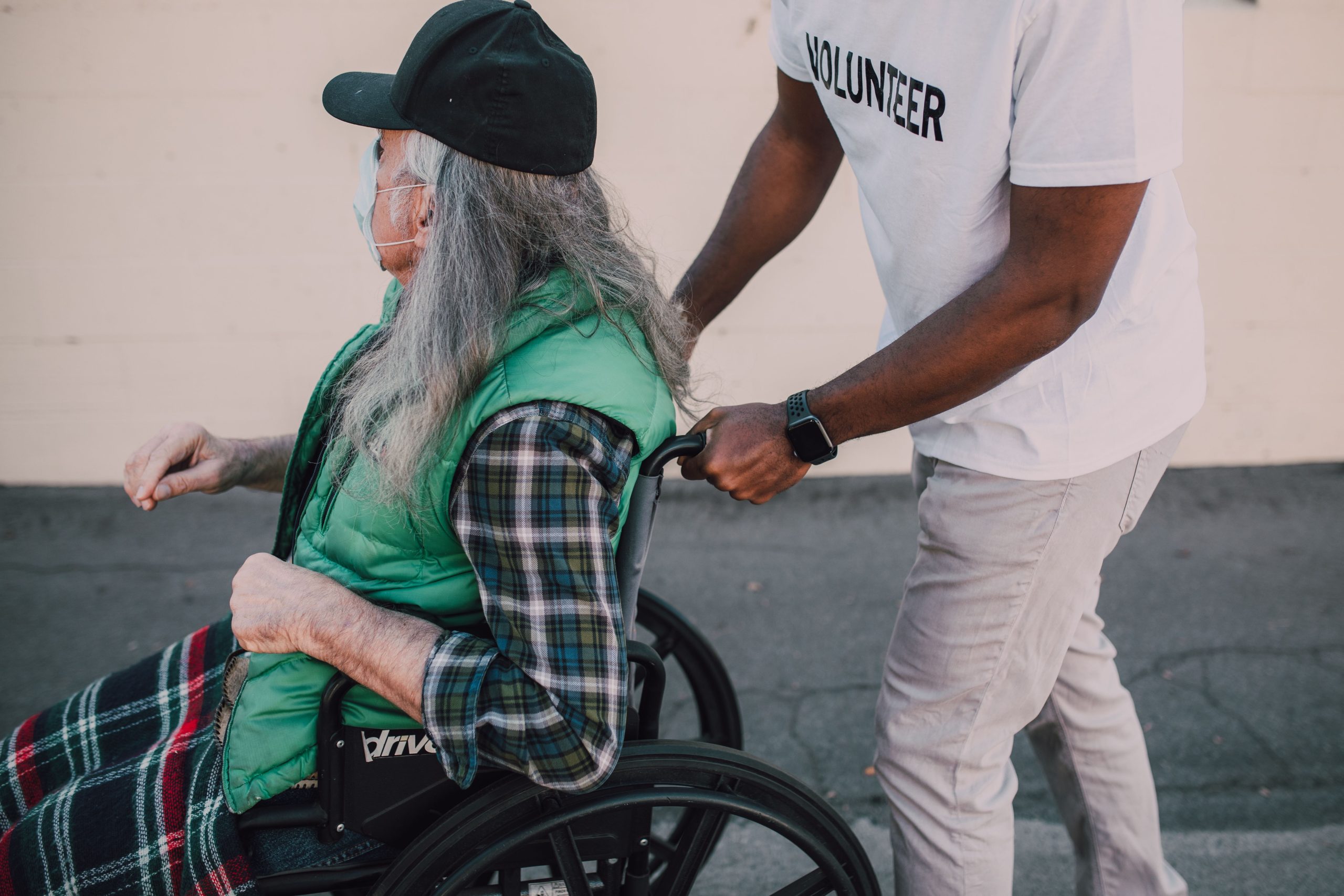 Nonprofit volunteer assisting an older adult using a wheelchair